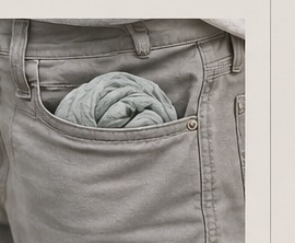 Gray Hour scarf tucked into a jeans pocket